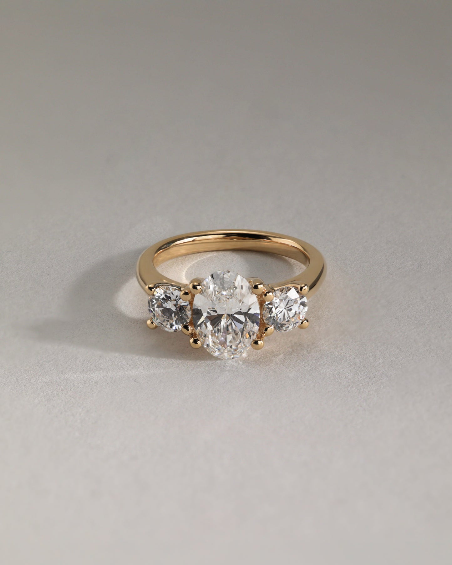 Grace - Oval Claw Trilogy with Round Side Stones, Open Trellis Gallery and Tapered Band Engagement Ring - Platinum - Lifestyle