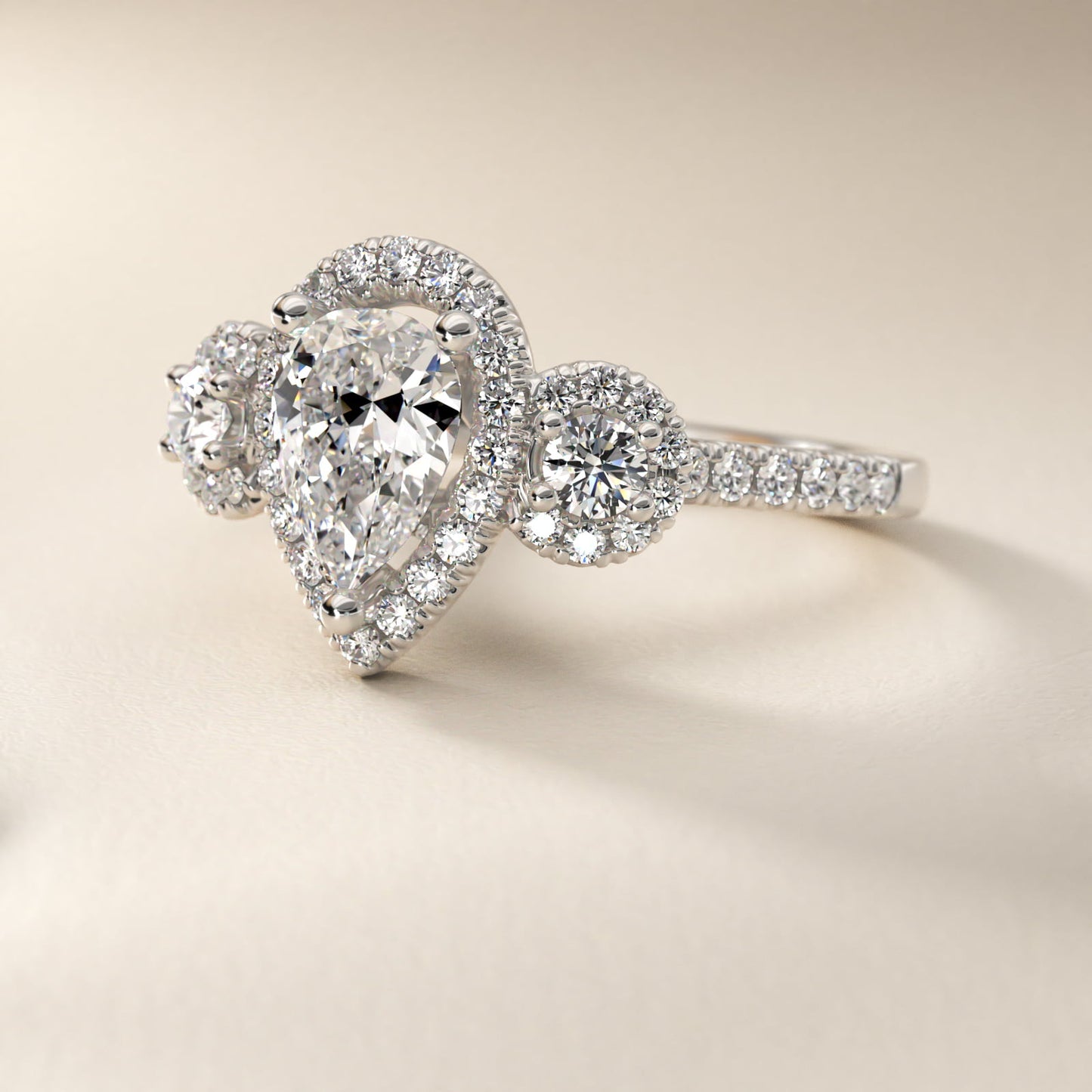 Three-Stone Halo Diamond Engagement Ring in Platinum - Pear Center