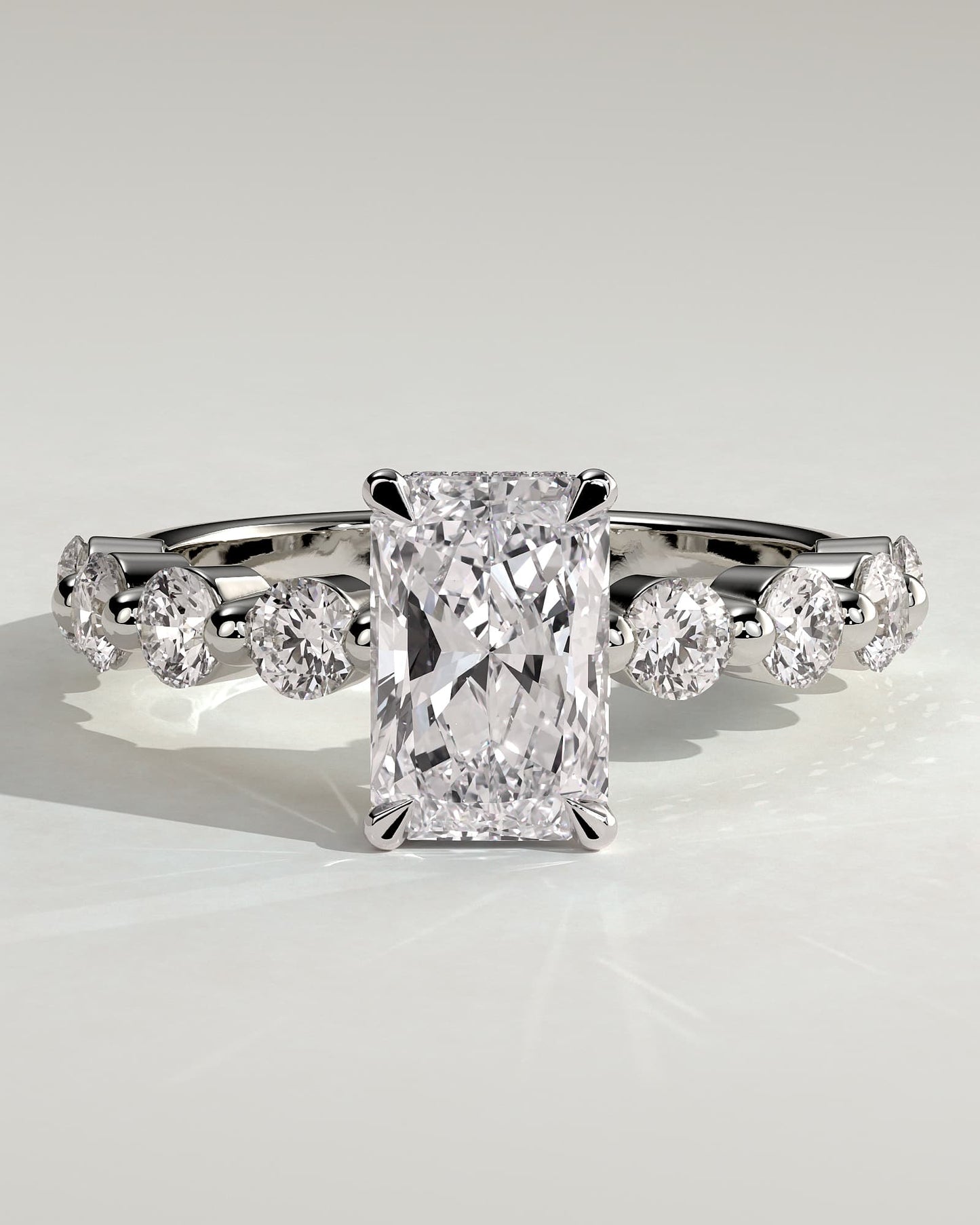 Josephine - Radiant Claw Solitaire with Round Accent Stones and Wrap Around Hidden Halo Engagement Ring - White Gold