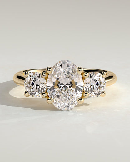 Grace - Oval Claw Trilogy with Round Side Stones, Open Trellis Gallery and Tapered Band Engagement Ring - Yellow Gold