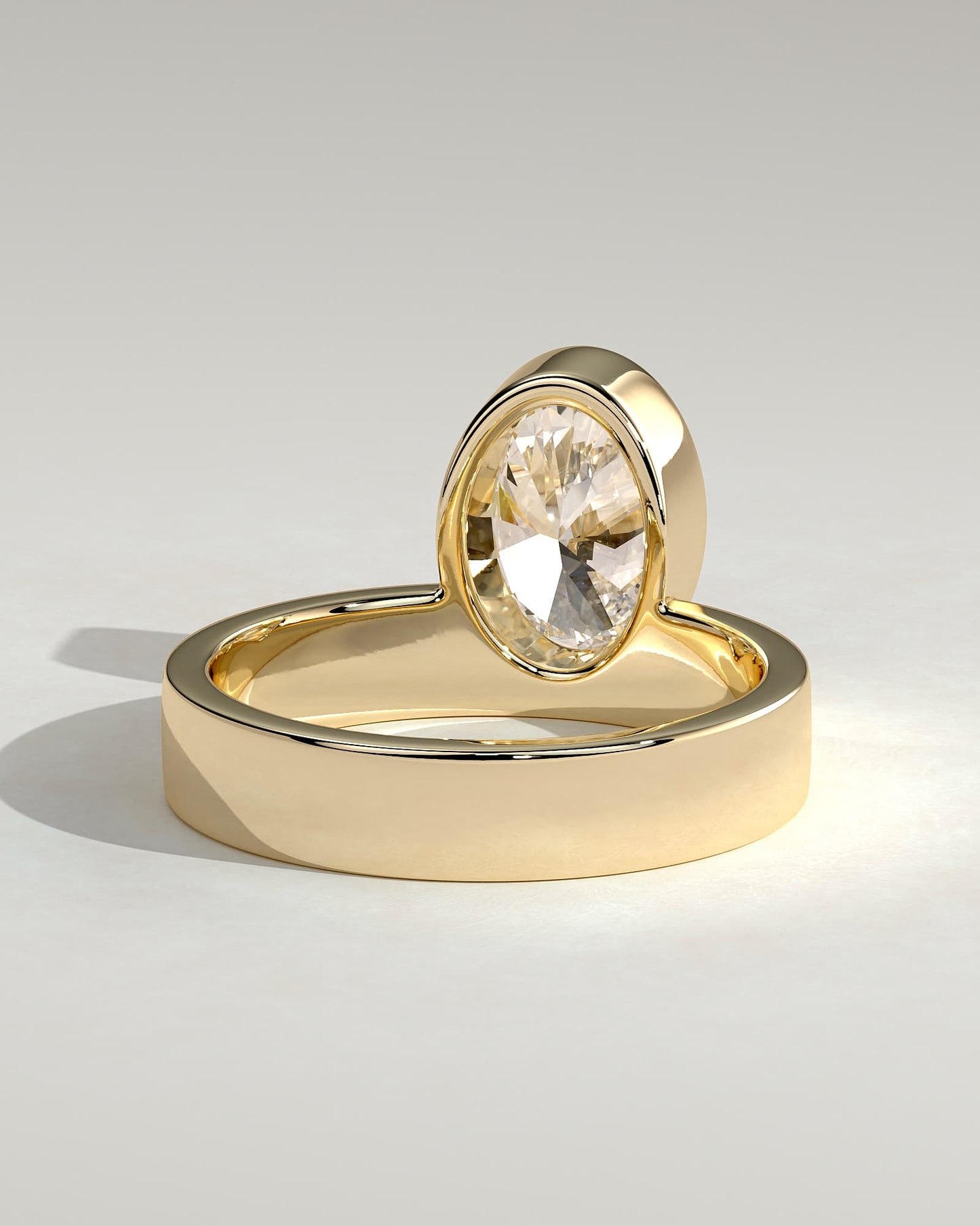 Carmen - Oval Bezel Solitaire with Offset Setting and Flat Cigar Band Engagement Ring - Yellow Gold