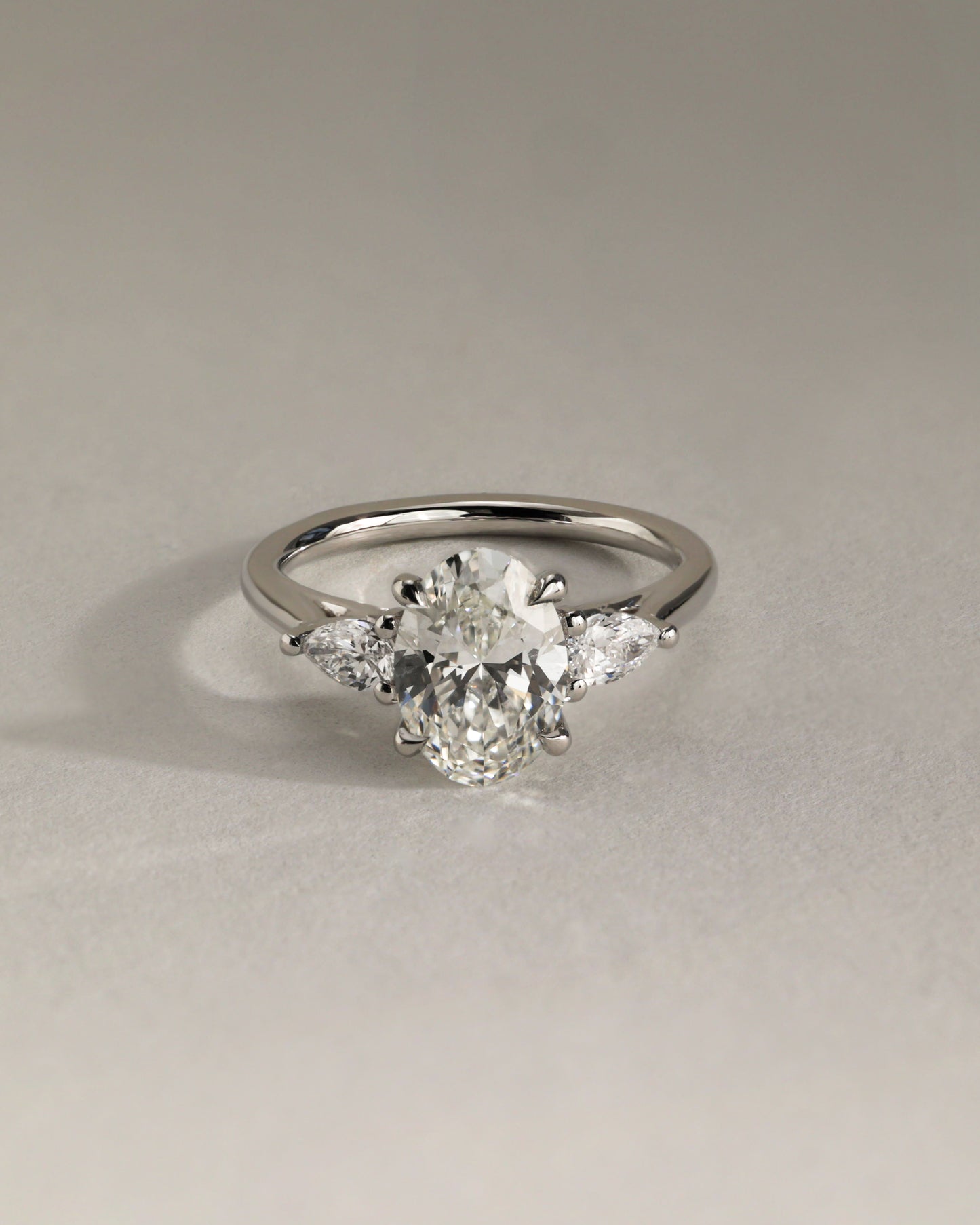 Amara - Oval Claw Trilogy with Pear Side Stones and Open Trellis Gallery Engagement Ring - Platinum - Lifestyle