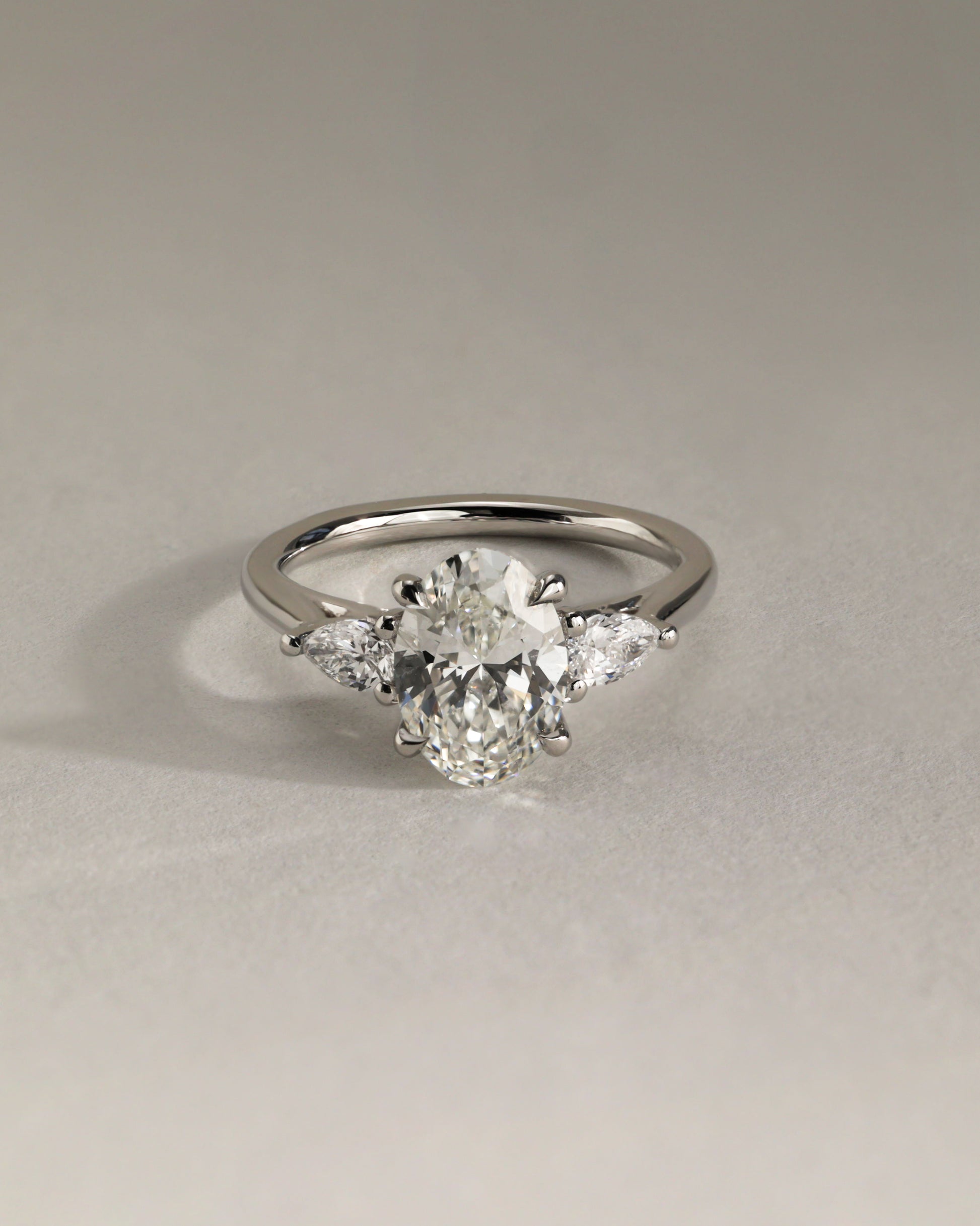Amara - Oval Claw Trilogy with Pear Side Stones and Open Trellis Gallery Engagement Ring - Platinum - Lifestyle