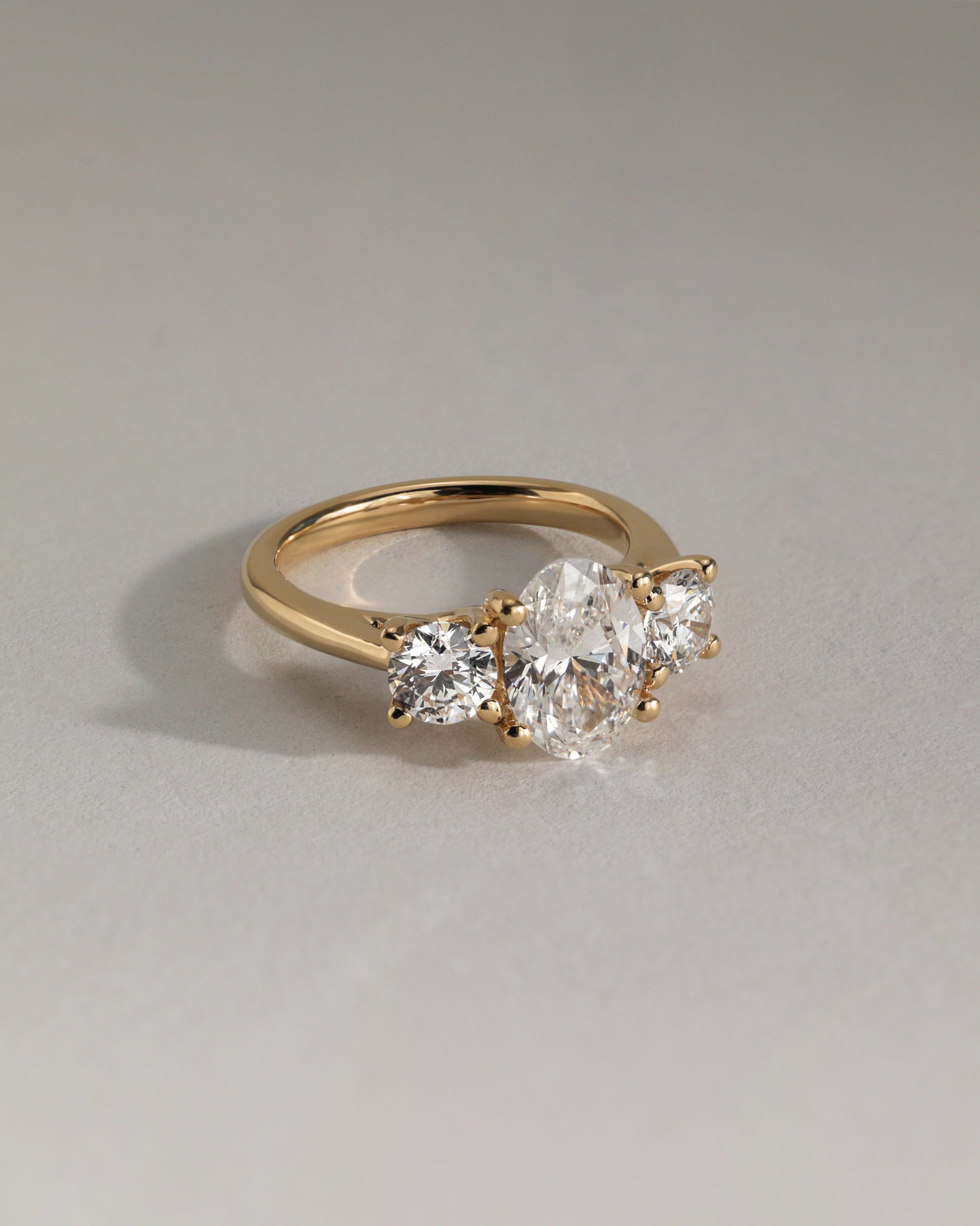 Grace - Oval Claw Trilogy with Round Side Stones, Open Trellis Gallery and Tapered Band Engagement Ring - Platinum - Lifestyle