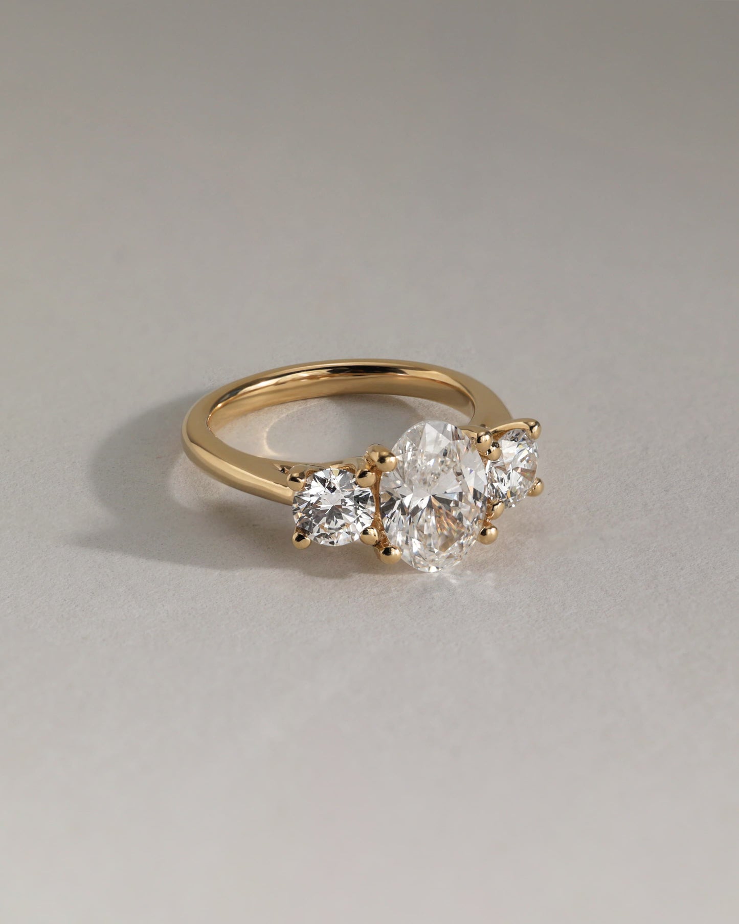Grace - Oval Claw Trilogy with Round Side Stones, Open Trellis Gallery and Tapered Band Engagement Ring - White Gold