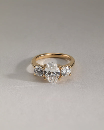 Grace - Oval Claw Trilogy with Round Side Stones, Open Trellis Gallery and Tapered Band Engagement Ring - Yellow Gold