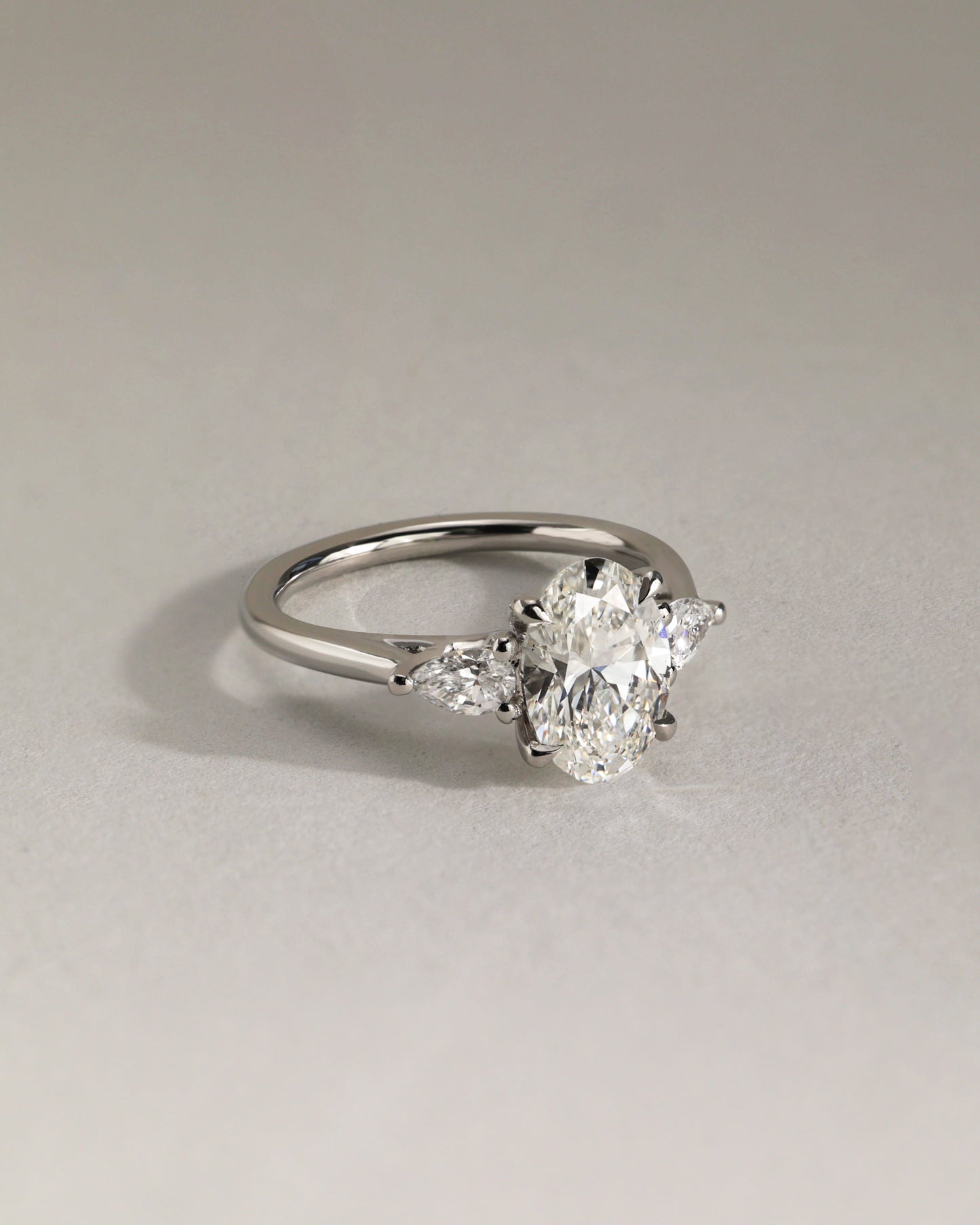 Amara - Oval Claw Trilogy with Pear Side Stones and Open Trellis Gallery Engagement Ring - Platinum - Lifestyle
