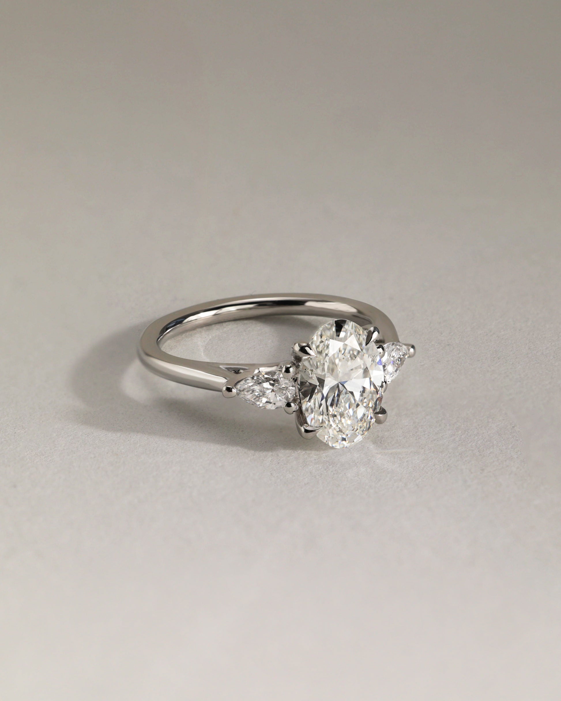 Amara - Oval Claw Trilogy with Pear Side Stones and Open Trellis Gallery Engagement Ring - Platinum - Lifestyle