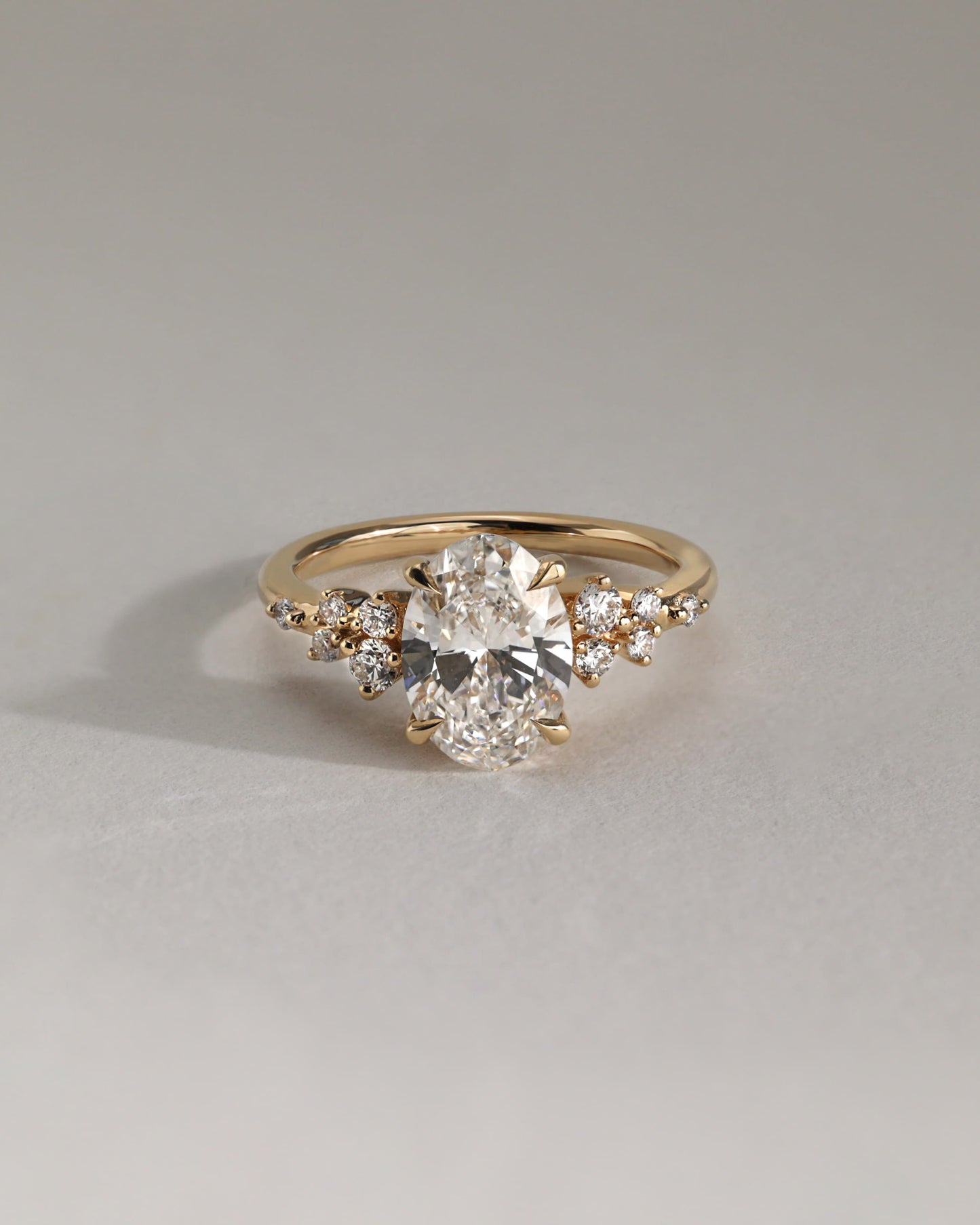 Bella - Oval Claw Solitaire with Clustered Round Shoulder Stones Engagement Ring - Yellow Gold