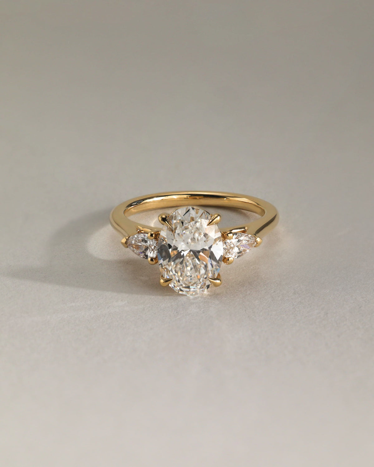 Alexia - Oval Claw Trilogy with Pear Side Stones and Cathedral Setting Engagement Ring - Yellow Gold