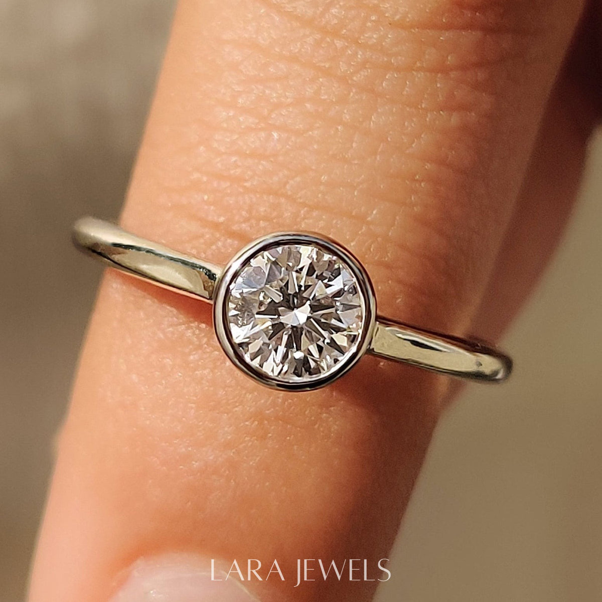 Lab grown round engagement ring in Bezel Solitaire Setting, available in Silver. IGI certified, ethically sourced, handcrafted at Lara Jewels.